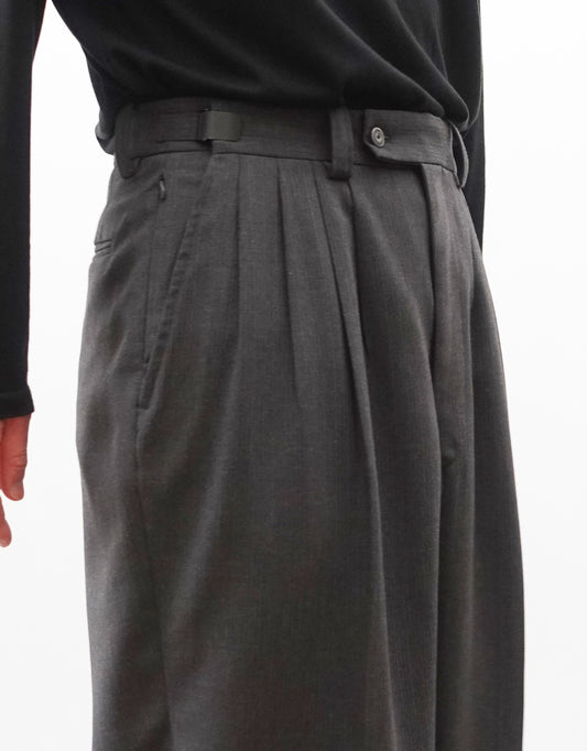 VOUILLON(ヴイヨン)のFour Pleats Wide Trousers - Gray Multi Stripe(4プリーツワイドトラウザーズ)。グレー地にマルチストライプを配した、4プリーツ仕様のワイドパンツ。ストライプによる脚長効果と立体的なシルエットが特徴。モデル着用左向きウエストアップ画像。