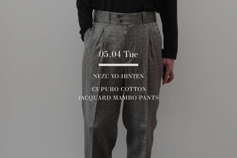 VOUILLON（ヴイヨン）マガジン「NEZU YO-HINTEN Mambo Pants Summer Tapered」のトップ画像。キュプラコットン・ジャガード織りのグレーのマンボパンツ。腰元の深いタックと素材の光沢感が伝わるスタイリング写真。