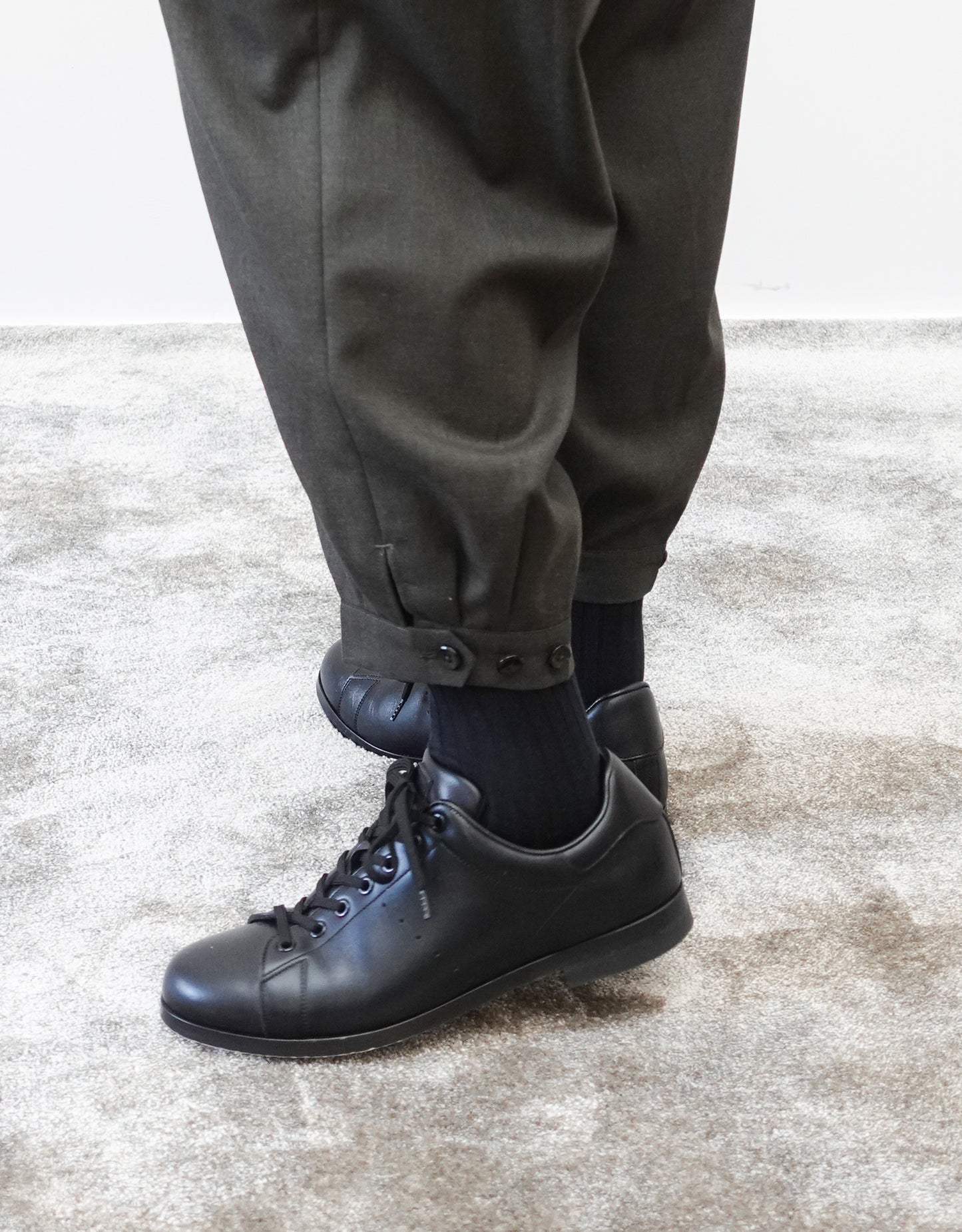 VOUILLON（ヴイヨン）のTriple Tuck Harlem Slacks - DARK OLIVE（トリプルタックハーレムスラックス）。腰元の3タックによるボリューム感と、裾にかけて絞られたハーレムシルエットが特徴のダークオリーブ・ワイドパンツ。シックでモードな上品な印象。裾の瑛人タックとシルエット調整の３つボタンの画像。