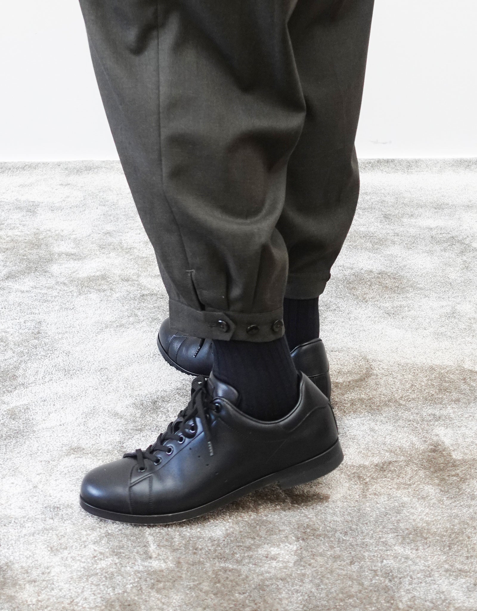 VOUILLON（ヴイヨン）のTriple Tuck Harlem Slacks - DARK OLIVE（トリプルタックハーレムスラックス）。腰元の3タックによるボリューム感と、裾にかけて絞られたハーレムシルエットが特徴のダークオリーブ・ワイドパンツ。シックでモードな上品な印象。裾の瑛人タックとシルエット調整の３つボタンの画像。