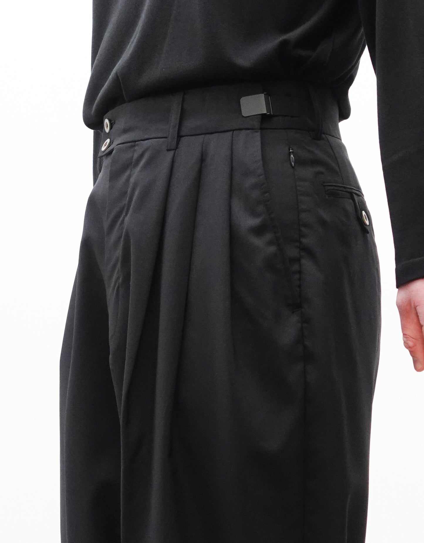 VOUILLON（ヴイヨン）のTriple Tuck Harlem Slacks - Black（トリプルタックハーレムスラックス）。腰元の3タックによるボリューム感と、裾にかけて絞られたハーレムシルエットが特徴のブラック・コクーンシルエットのパンツ。右斜めからウエスト寄りの画像。