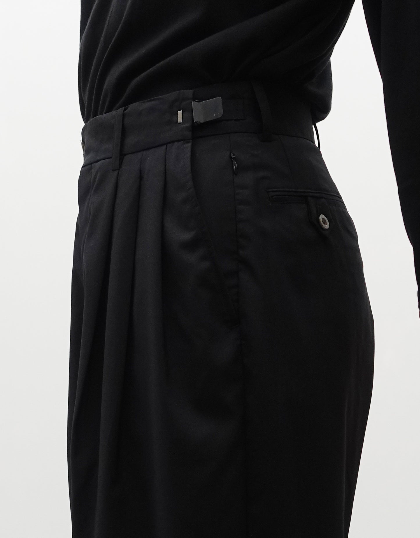 VOUILLON（ヴイヨン）のTriple Tuck Harlem Slacks - Black（トリプルタックハーレムスラックス）。腰元の3タックによるボリューム感と、裾にかけて絞られたハーレムシルエットが特徴のブラック・コクーンシルエットのパンツ。右斜めからウエスト寄りでウエストのアジャスター紹介画像。