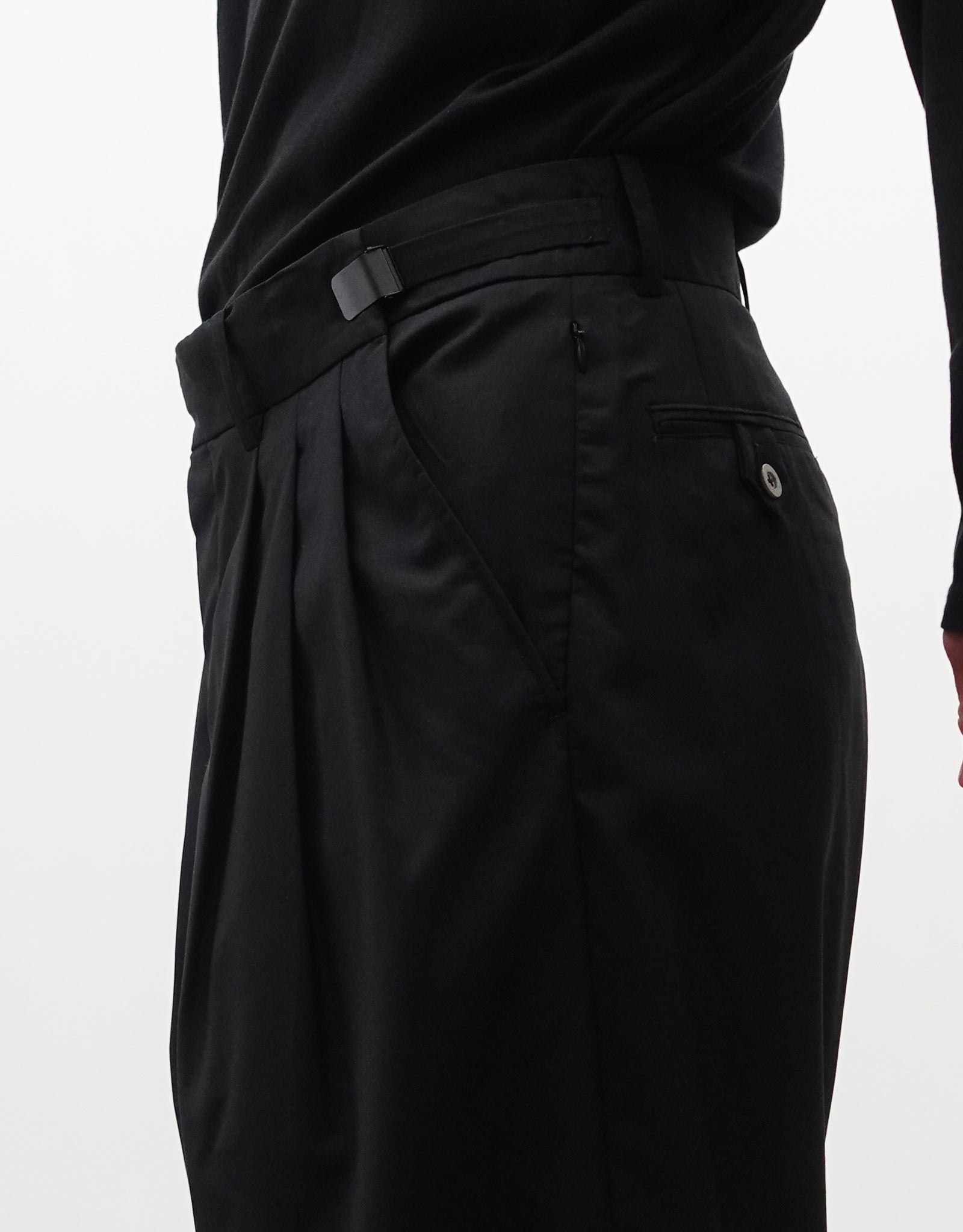 VOUILLON（ヴイヨン）のTriple Tuck Harlem Slacks - Black（トリプルタックハーレムスラックス）。腰元の3タックによるボリューム感と、裾にかけて絞られたハーレムシルエットが特徴のブラック・コクーンシルエットのパンツ。右斜めからウエスト寄りでアジャスター開閉紹介画像。