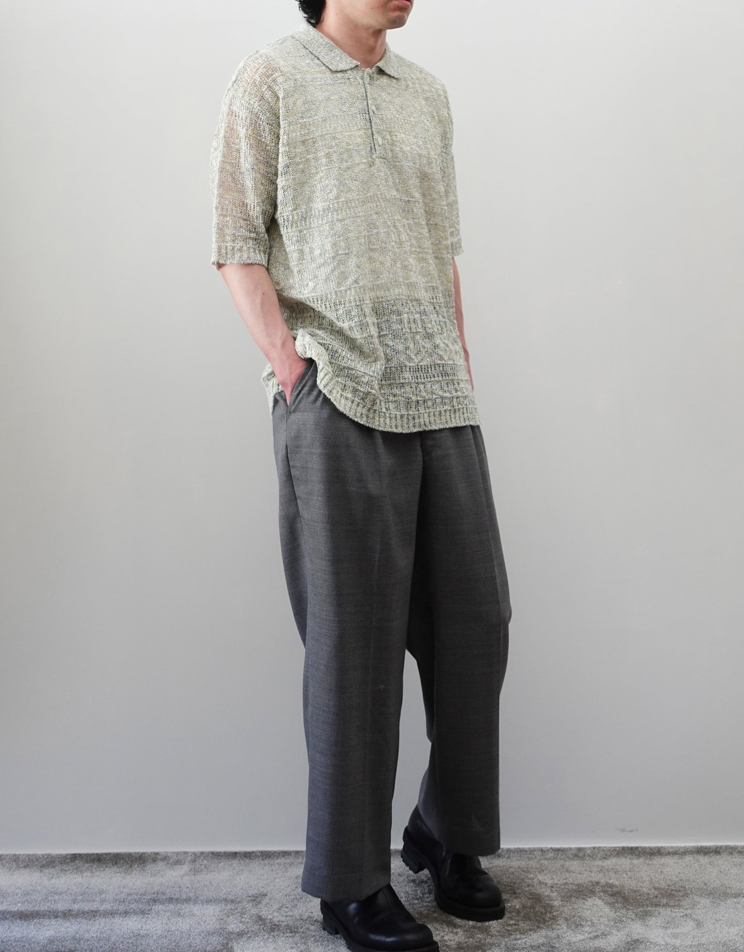 VOUILLON（ヴイヨン）のOpenwork Stitch Polo Linen Knit Shirt（オープンワークステッチポロリネンニットシャツ）。涼しげな透かし編み（オープンワーク）を施した、リネン素材のポロ襟ニットシャツ。独特の透け感とリラクシングなシルエットが特徴。モデル着用左斜め前向き全身画像。