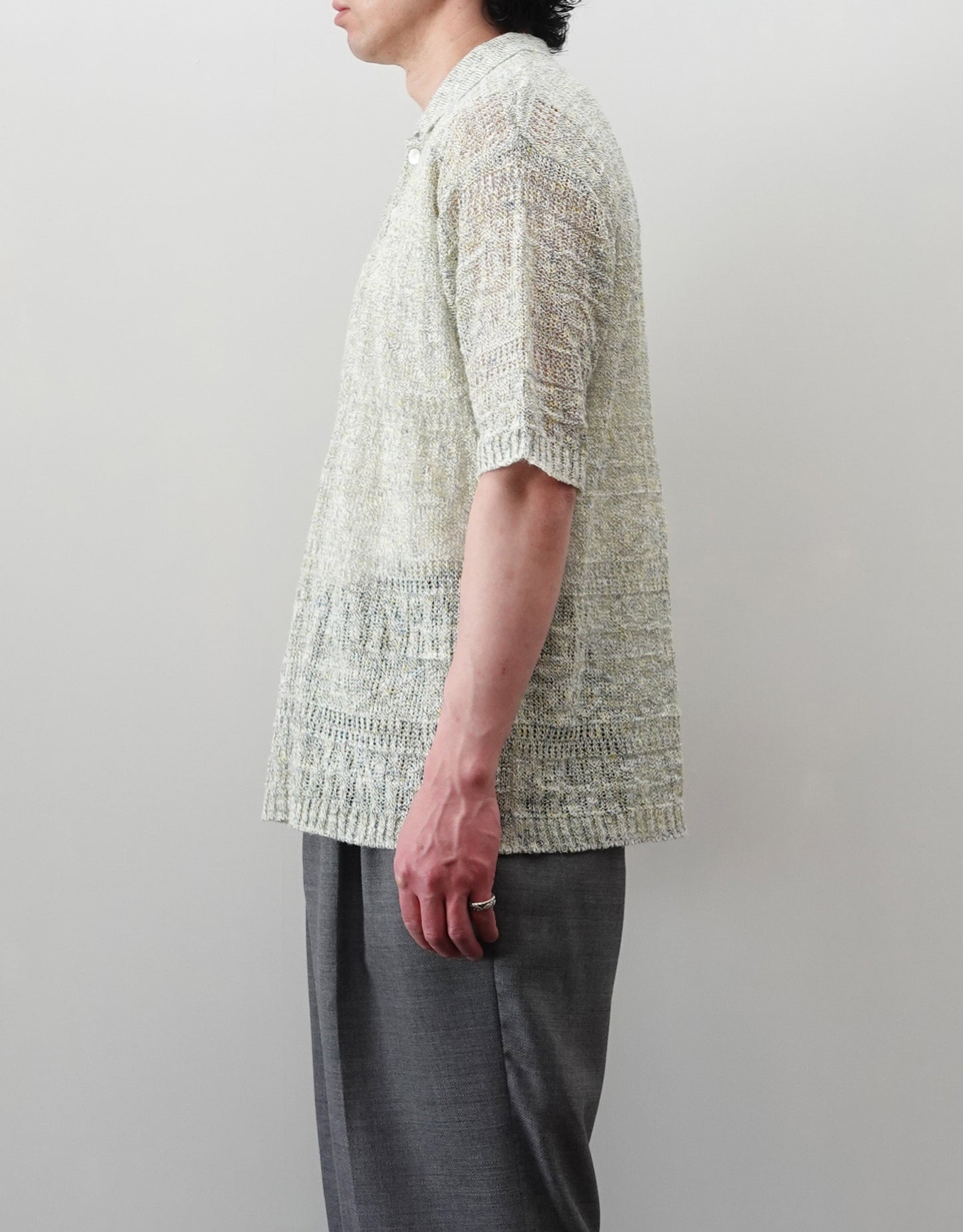 VOUILLON（ヴイヨン）のOpenwork Stitch Polo Linen Knit Shirt（オープンワークステッチポロリネンニットシャツ）。涼しげな透かし編み（オープンワーク）を施した、リネン素材のポロ襟ニットシャツ。独特の透け感とリラクシングなシルエットが特徴。モデル着用右向き画像。