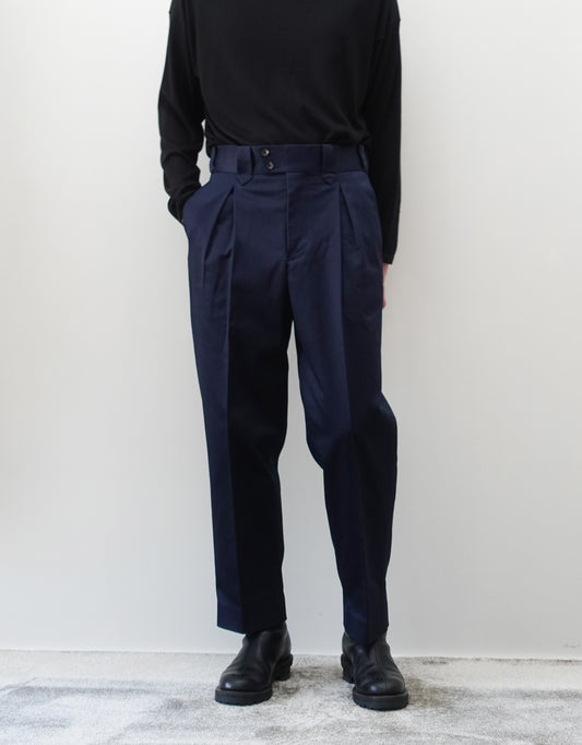 VOUILLON（ヴイヨン）のNEZU YO-HINTEN FINX COTTON SATIN MAMBO PANTS（フィンクスコットンサテンマンボパンツ）。最高級フィンクスコットンのサテン地が放つ、上品な光沢と美しいネイビーの色相。腰元の2タックから裾へかけて急激に絞られたテーパードシルエット。モデル着用正面画像。