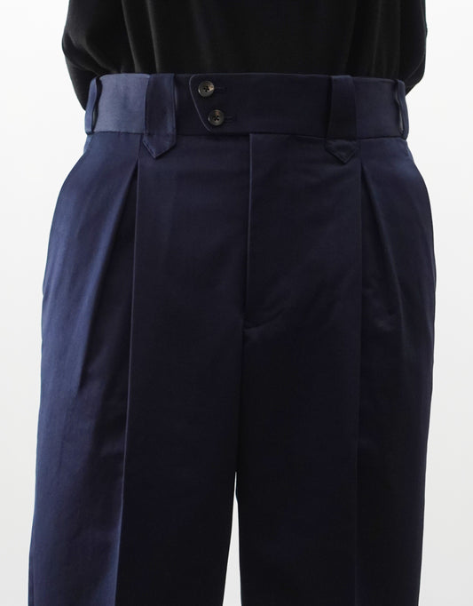 VOUILLON（ヴイヨン）のNEZU YO-HINTEN FINX COTTON SATIN MAMBO PANTS（フィンクスコットンサテンマンボパンツ）。最高級フィンクスコットンのサテン地が放つ、上品な光沢と美しいネイビーの色相。腰元の2タックから裾へかけて急激に絞られたテーパードシルエット。モデル着用正面ウエスト画像。