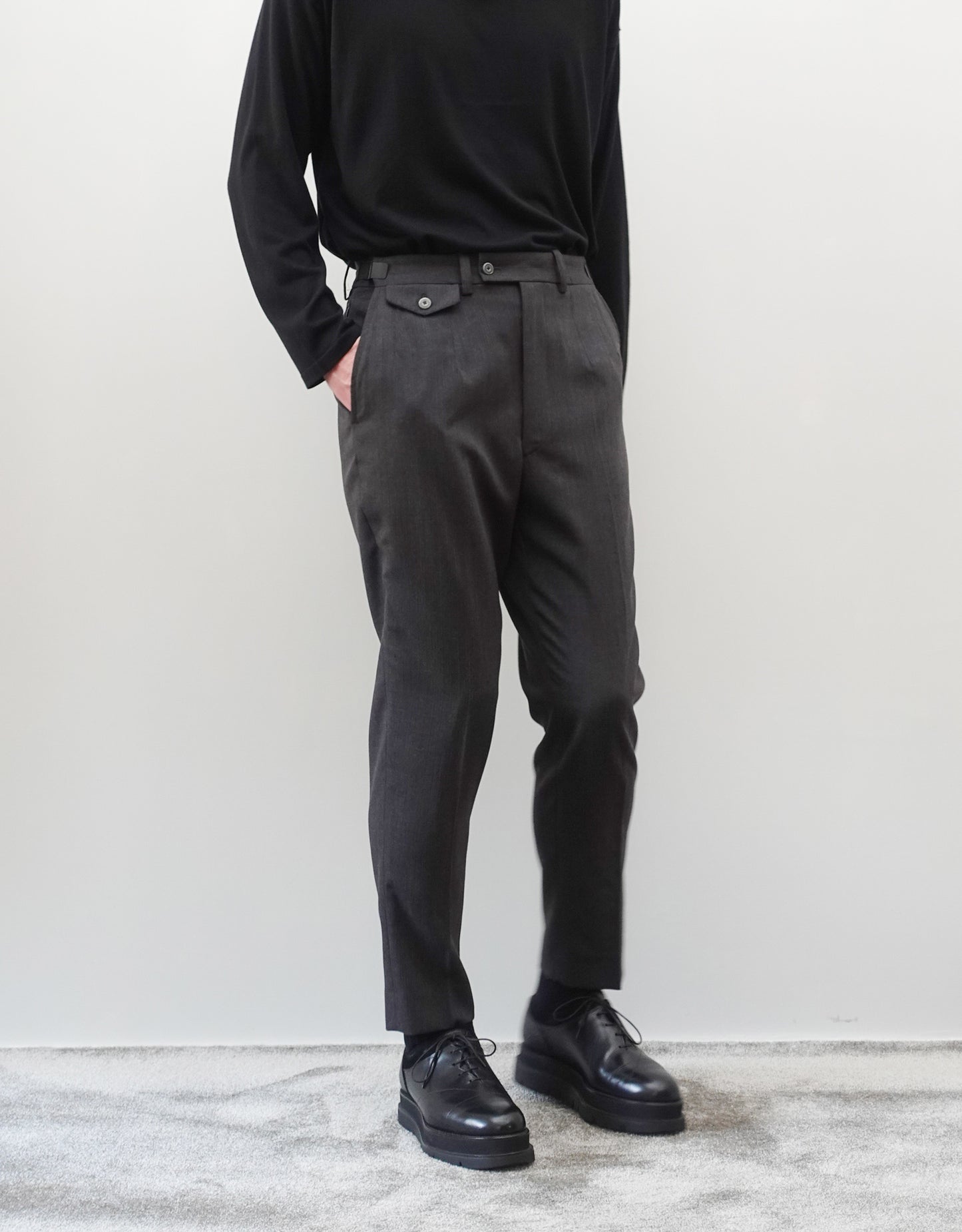 VOUILLON（ヴイヨン）のTwo Darts Slim Trousers - Gray Multi Stripe（2ダーツスリムトラウザーズ）。グレーマルチストライプ柄の端正な生地に、ウエスト回りをすっきり見せる2ダーツ仕様のスリムパンツ。美しいスリムテーパードシルエット。モデル着用正面画像。