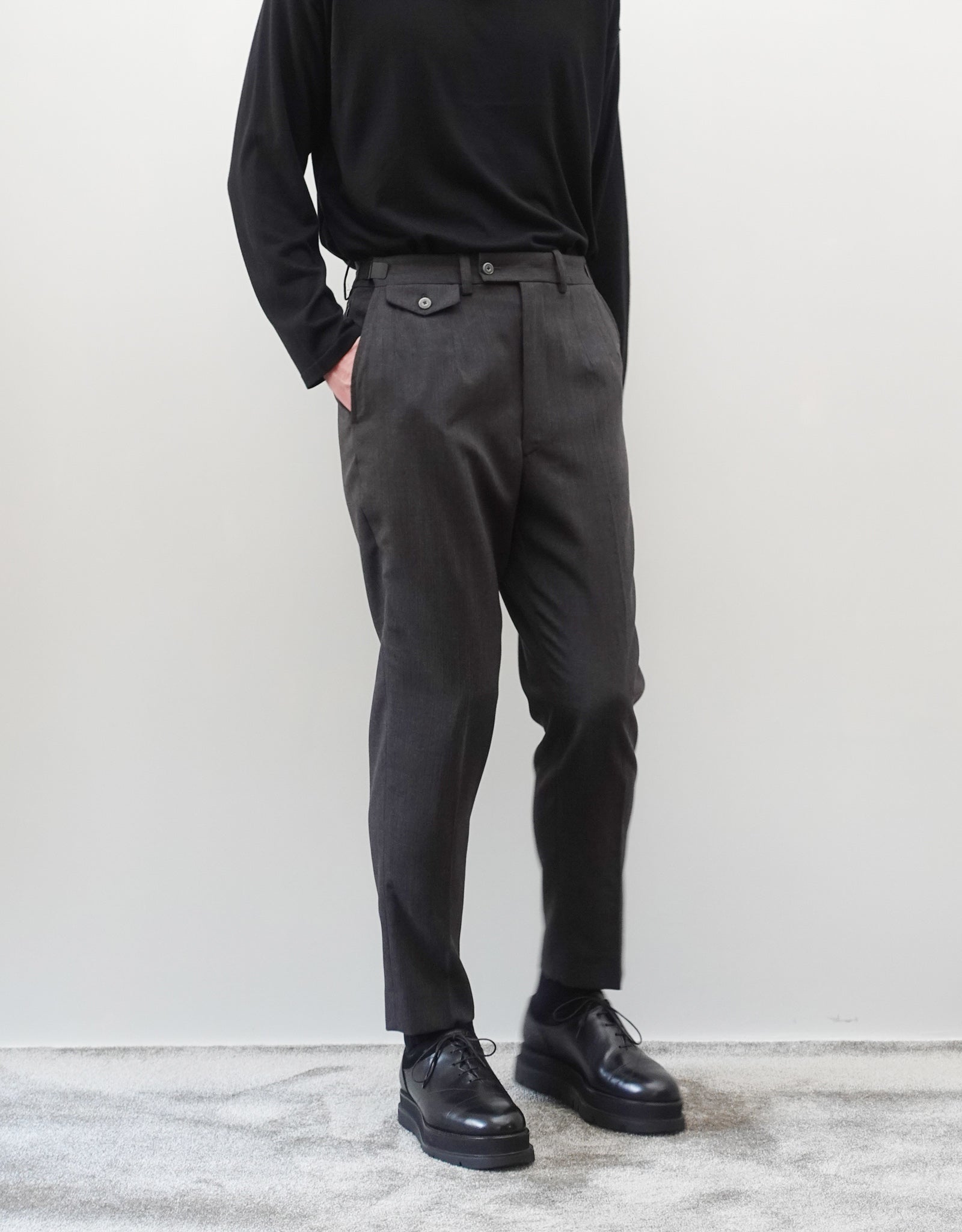 VOUILLON（ヴイヨン）のTwo Darts Slim Trousers - Gray Multi Stripe（2ダーツスリムトラウザーズ）。グレーマルチストライプ柄の端正な生地に、ウエスト回りをすっきり見せる2ダーツ仕様のスリムパンツ。美しいスリムテーパードシルエット。モデル着用正面画像。