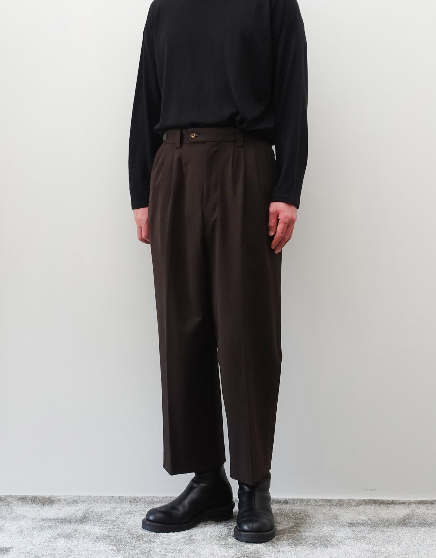 VOUILLON（ヴイヨン）のFour Pleats Wide Trousers - Dark Chocolate（4プリーツワイドトラウザーズ）。ダークチョコレート（深みのあるブラウン）のワイドシルエットと腰元の4プリーツ。モデルによる正面向きの着用画像。