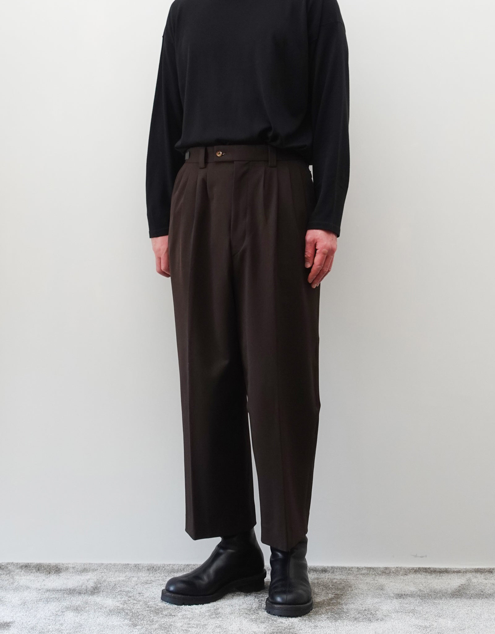 VOUILLON（ヴイヨン）のFour Pleats Wide Trousers - Dark Chocolate（4プリーツワイドトラウザーズ）。ダークチョコレート（深みのあるブラウン）のワイドシルエットと腰元の4プリーツ。モデルによる正面向きの着用画像。
