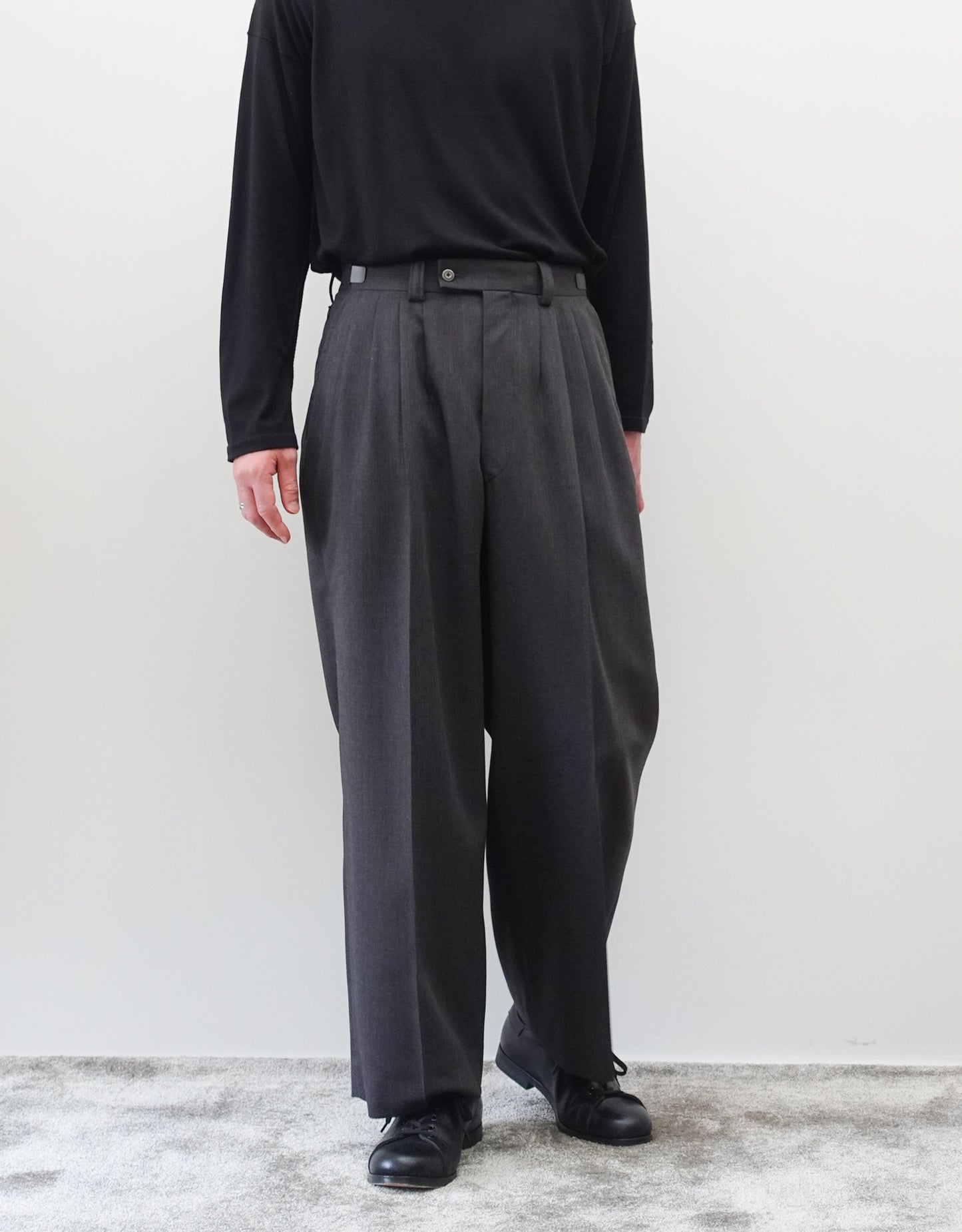 VOUILLON（ヴイヨン）のFour Pleats Wide Trousers - Gray Multi Stripe（4プリーツワイドトラウザーズ）。グレー地にマルチストライプを配した、4プリーツ仕様のワイドパンツ。ストライプによる脚長効果と立体的なシルエットが特徴。モデル着用正面画像。