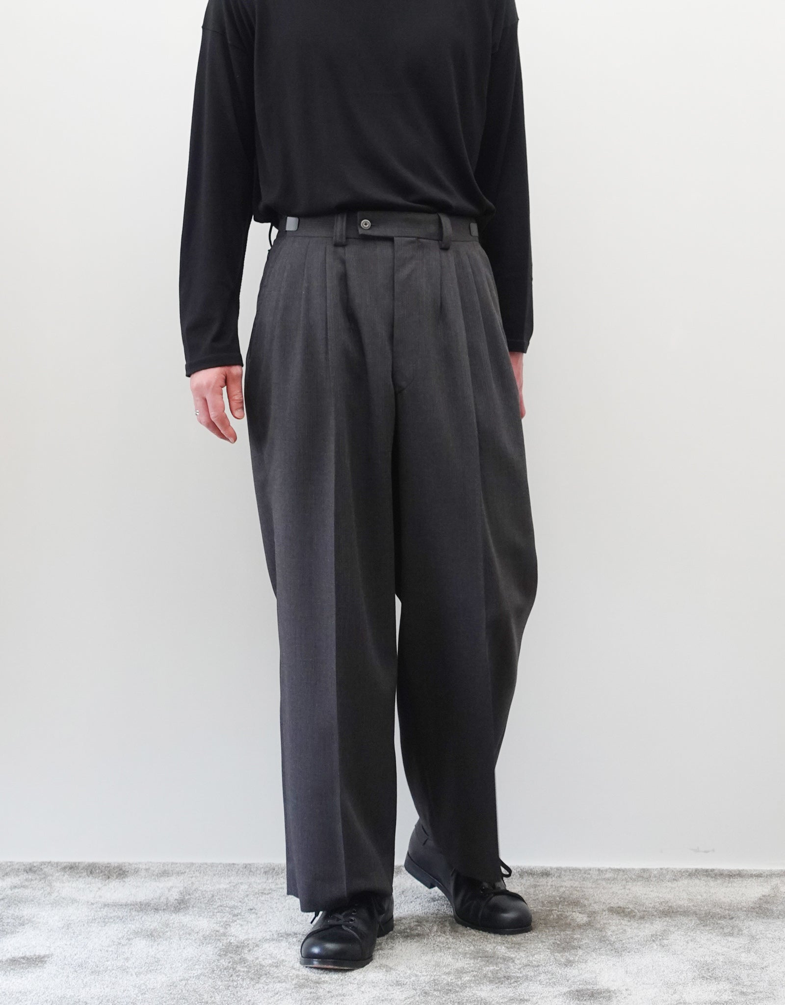 VOUILLON（ヴイヨン）のFour Pleats Wide Trousers - Gray Multi Stripe（4プリーツワイドトラウザーズ）。グレー地にマルチストライプを配した、4プリーツ仕様のワイドパンツ。ストライプによる脚長効果と立体的なシルエットが特徴。モデル着用正面画像。