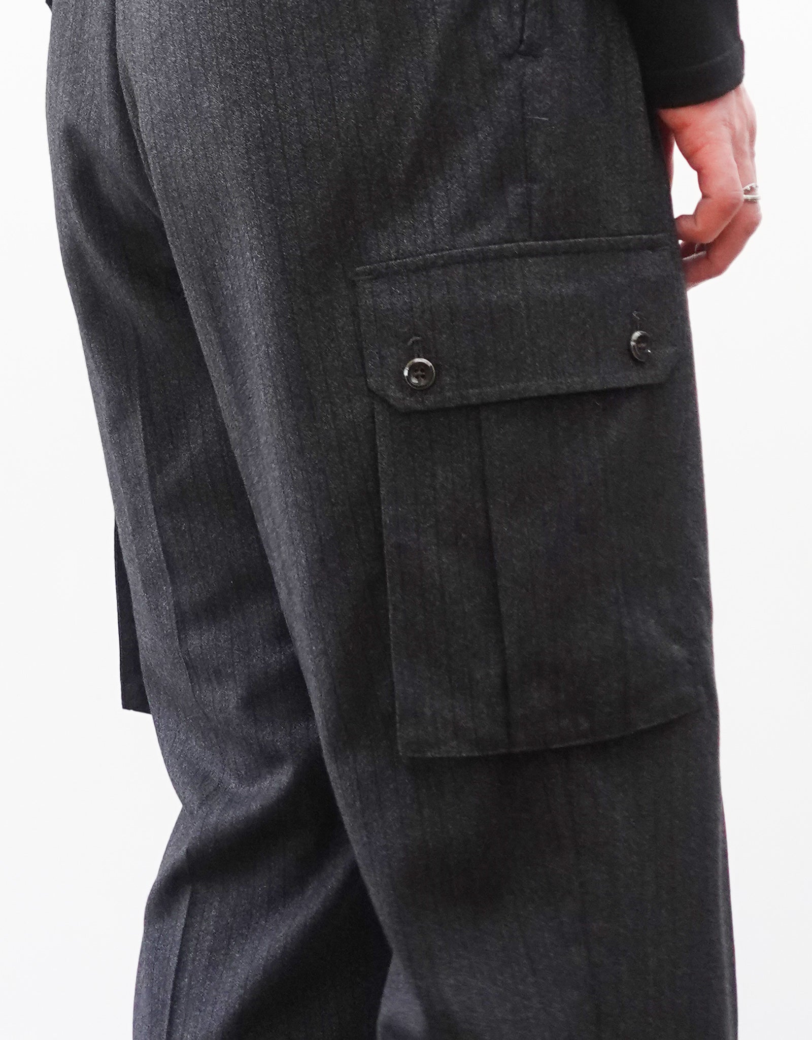 VOUILLON（ヴイヨン）のTwo Tuck Cargo Slacks - chacoal Stripe（2タックカーゴスラックス - チャコールストライプ）。上質な生地で立体的に仕上げることでシルエットの美しさとカーゴポケットの機能性の両立させたカーゴパンツ。モデル着用カーゴポケット画像。