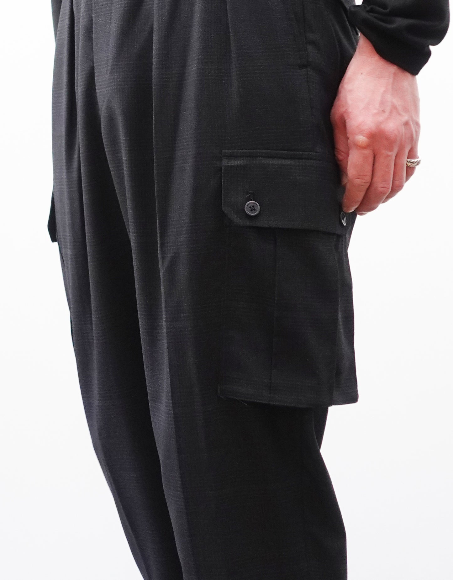 VOUILLON（ヴイヨン）のTwo Tuck Cargo Slacks - Black Glen Check（ツータックカーゴスラックス）。黒を基調としたシックなグレンチェック柄生地に、腰元のツータックと上品なサイドポケットを配したモードなカーゴパンツ。モデル着用左側のカーゴポケットを写した画像。
